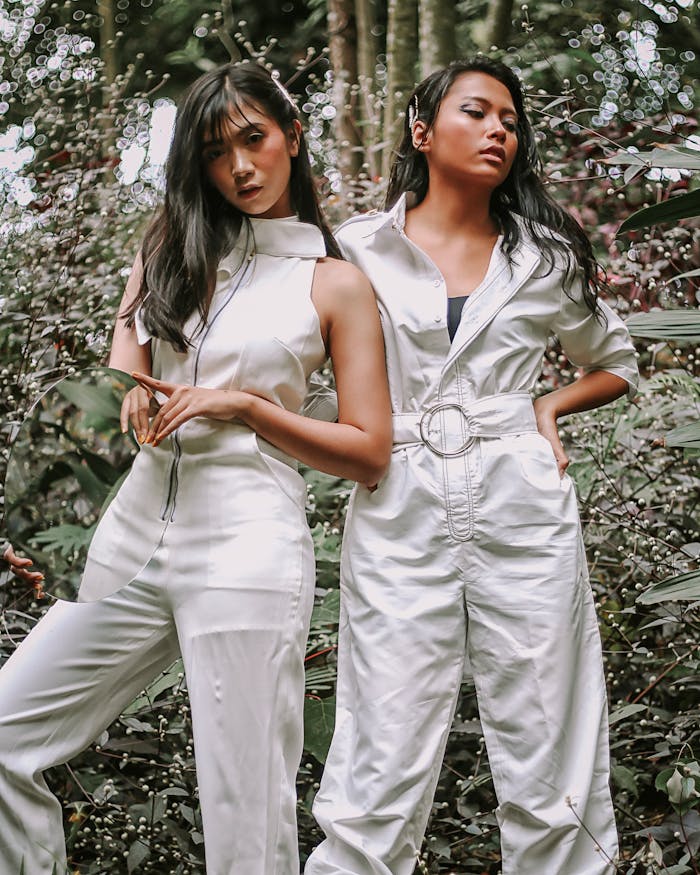 creative-02 Fashion models posing in stylish jumpsuits amidst tropical greenery.